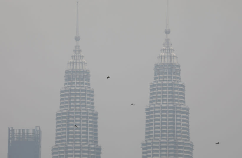   Las Torres Gemelas Petronas quedan envueltas por la bruma en Kuala Lumpur, Malasia. (credit: REUTERS/LIM HUEY TENG)