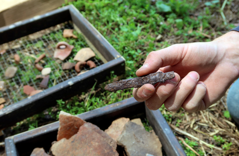  A person holds a small iron blade that was found buried in an immense underground hideout comprising narrow tunnels and large storage spaces that, according to the Israel Antiquities Authority (IAA), was dug by Jewish villagers nearly 2,000 years ago at a time of revolt against the Roman Empire. (credit: REUTERS/Ari Rabinovitch)