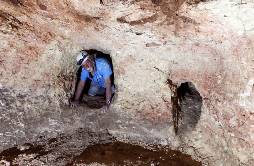  Yinon Shivtiel, historiador del Colegio Académico de Zefat, se arrastra por una abertura de una cueva, parte de un inmenso escondite subterráneo compuesto por estrechos túneles y grandes espacios de almacenamiento que fue excavado por los aldeanos judíos hace casi 2.000 años. (credit: REUTERS/Ari Rabinovitch)