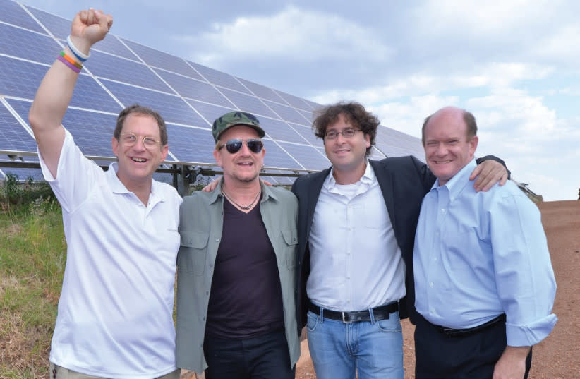 Empresario israelí Yosef Abramowitz recibe al senador estadounidense Chris Coons y a Bono en instalación solar en Ruanda. (credit: Courtesy)