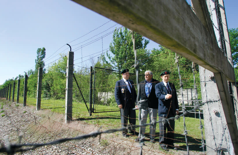 Los veteranos judíos estadounidenses de la Segunda Guerra Mundial Don Golde (derecha), Cy Mermelstein (izquierda) y Shep Waldman (centro) junto a la alambrada del campo de concentración en el 62º aniversario de la liberación en Dachau, el 13 de mayo de 2007. (credit: Michaela Rehle/Reuters)