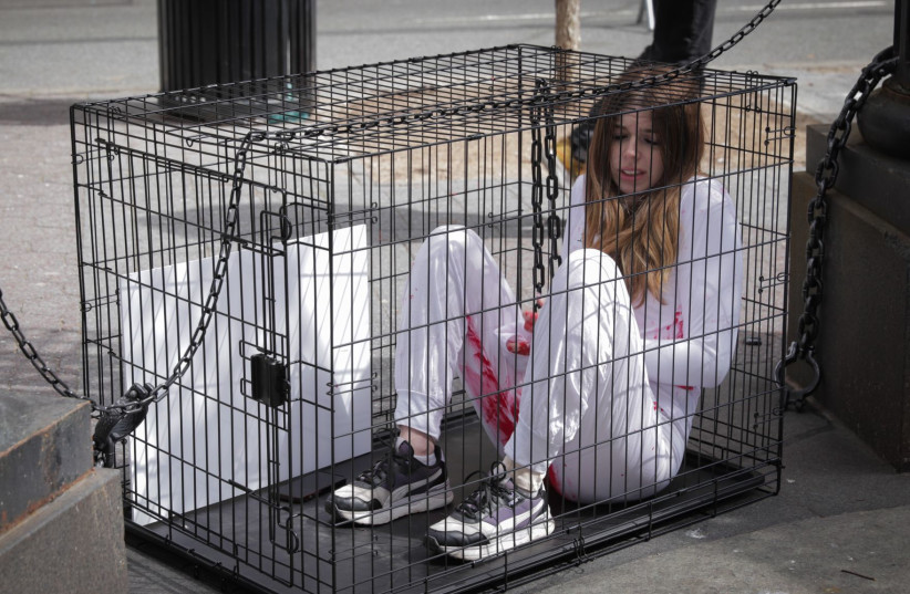  Activists chained in cages to remind passerbys what life in captivity looks like, April 7, 2024.  (credit: Hostages and Missing Families Forum)