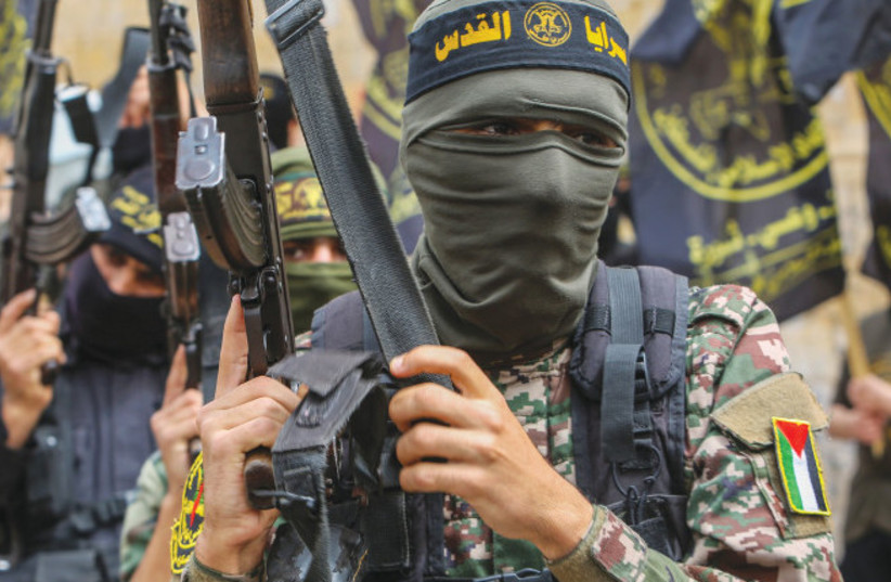 Simpatizantes de Hamás y la Yihad Islámica participan en una concentración celebrada el año pasado en el sur de la Franja de Gaza para celebrar un atentado mortal con disparos en Tel Aviv. (credit: ATTIA MUHAMMED/FLASH90)
