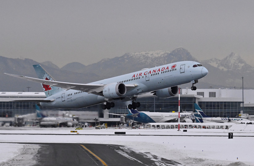  An Air Canada plane takes off following a snow storm at Vancouver International Airport in Richmond, British Columbia, Canada December 22, 2022. (credit: REUTERS/JENNIFER GAUTHIER)