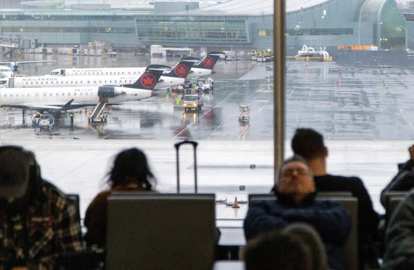  Los aviones de Air Canada están preparados mientras la gente espera para facturar sus vuelos durante una tormenta de invierno en el Aeropuerto Internacional Toronto Pearson en Mississauga, Ontario, Canadá 23 de diciembre 2022. (credit: REUTERS/CARLOS OSORIO)