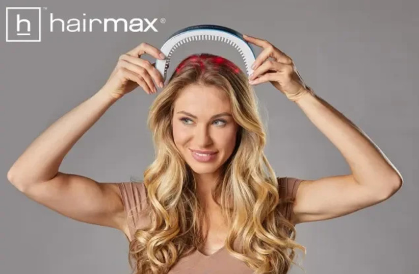   A woman uses the hairmax laser arc 41 for treatment against hair loss and baldness / hairmax (credit: PR)