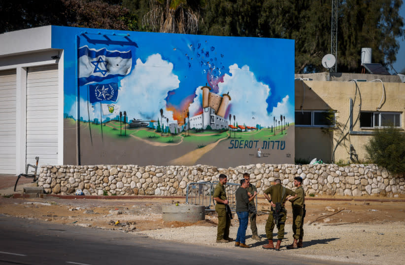  Soldados israelíes junto a una pintada en el emplazamiento de la antigua comisaría de policía de Sderot, atacada por terroristas de Hamás el 7 de octubre de 2023, en la ciudad de Sderot, en el sur de Israel, el 11 de marzo de 2024. (credit: Chaim Goldberg/Flash90)