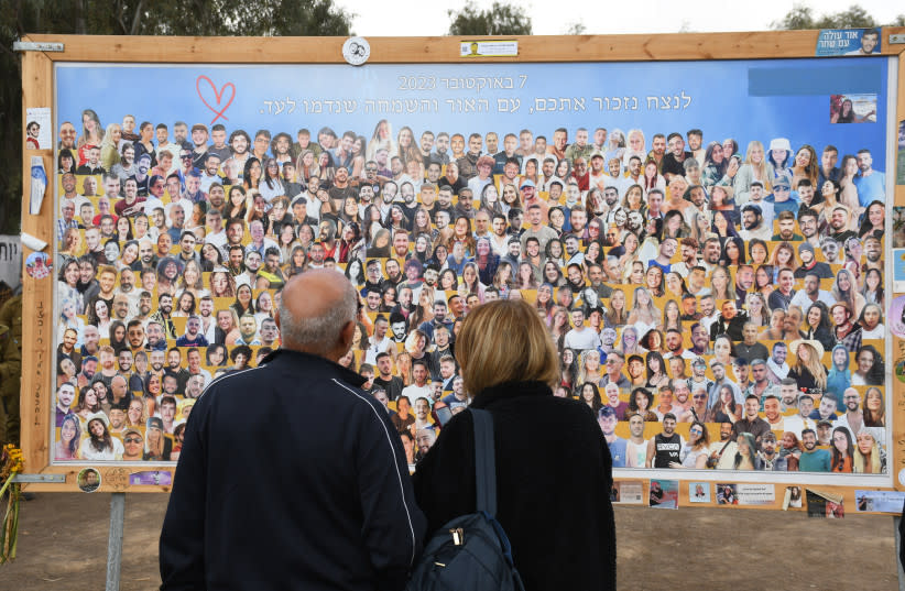  Un grupo de personas observa un tablón con los rostros de los fallecidos el 7 de octubre. (credit: SETH J. FRANTZMAN)