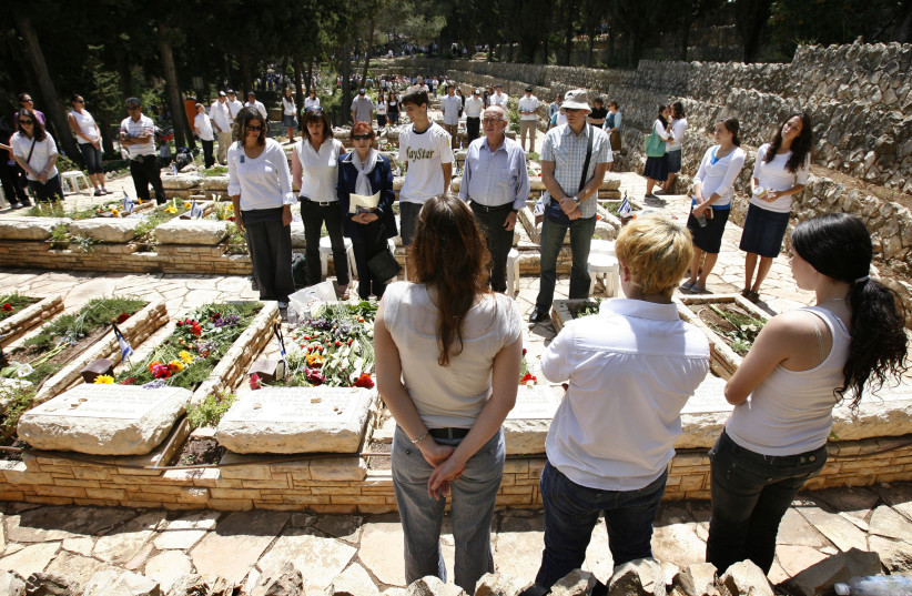  SAYING KADDISH at graves of fallen soldiers, on Remembrance Day at Jerusalem’s Mount Herzl.  (credit: MICHAL FATTAL/FLASH90)