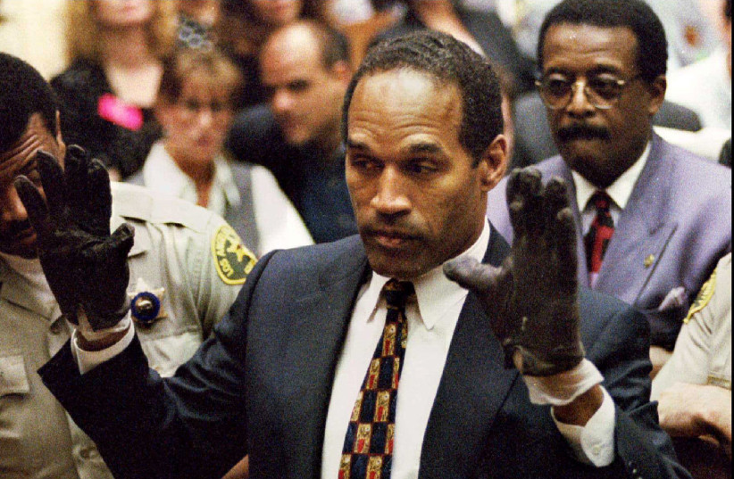  O.J. Simpson, wearing the blood stained gloves found by Los Angeles Police and entered into evidence in Simpson's murder trial, displays his hands to the jury at the request of prosecutor Christopher Darden in this file photograph from June 15, 1995 as his attorney Johnnie Cochran, Jr. (R.) looks o (credit: VIA REUTERS)
