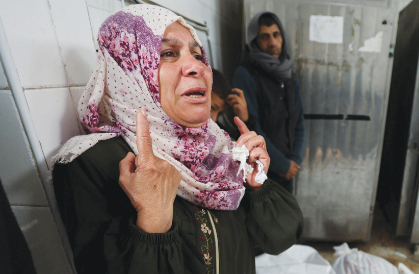  A WOMAN mourns amid bodies of people killed in the Gaza war. Deaths of large numbers of Gazan civilians, despite Israel’s efforts to minimize them, will continue to weaken Israel’s ties with the US, European Union countries, Abraham Accords members, and others, the writer argues.  (credit: REUTERS/Ramadan Abed)