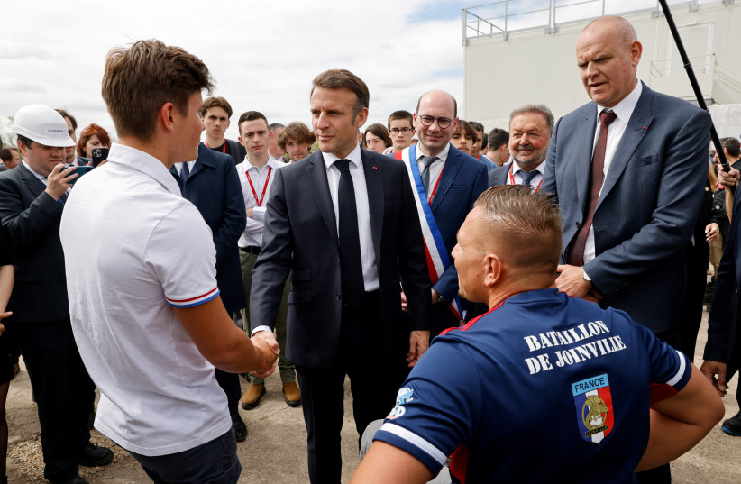  France's President Emmanuel Macron and Eurenco CEO Thierry Francou meet with military athletes who are training for the Paris 2024 Olympic and Paralympic Games during a visit to the powders and explosives company Eurenco plant in Bergerac, southwestern France April 11, 2024. (credit: REUTERS)