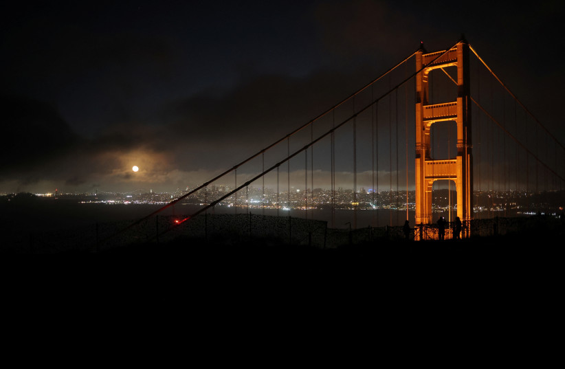 The Moon rises over the Golden Gate Bridge in San Francisco, California, US, August 2, 2023. (credit: REUTERS/CARLOS BARRIA)