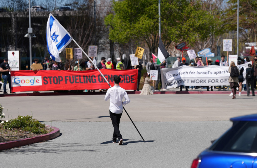  A counter-protester holding an Israeli flag walks into the parking lot near a protest at Google Cloud offices in Sunnyvale, California, U.S. on April 16, 2024. (credit: REUTERS/NATHAN FRANDINO)