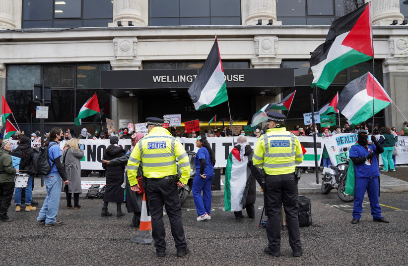  Police officers stand guard as National Health Service (NHS) workers protest outside Wellington House against the contract NHS has with Palantir Technologies UK, amid the ongoing conflict between Israel and the Palestinian Islamist group Hamas, in London, Britain April 3, 2024.  (credit: REUTERS/Maja Smiejkowska)