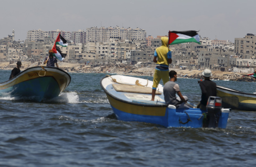  Palestinians riding boats hold Palestinian flags during a protest against the Israeli blocking of a boat of foreign activists from reaching Gaza, at the Seaport of Gaza City June 29, 2015. Israel said on Monday it had blocked a boat leading a four-vessel protest flotilla of foreign activists  (credit:  REUTERS/Suhaib Salem)