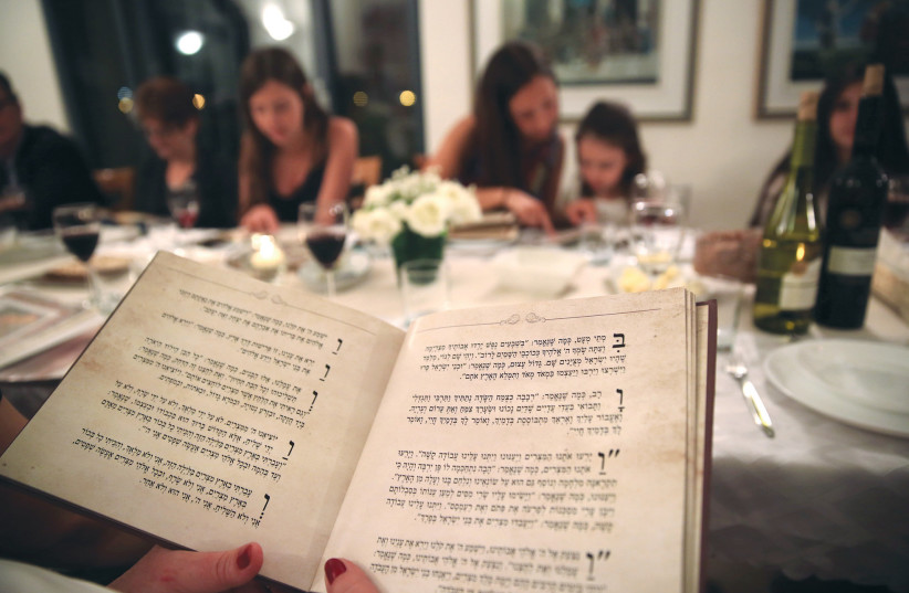  NO MATTER what traditions people bring to the Seder, the constant is the Haggadah. (credit: YAHAV GAMLIEL/FLASH90)