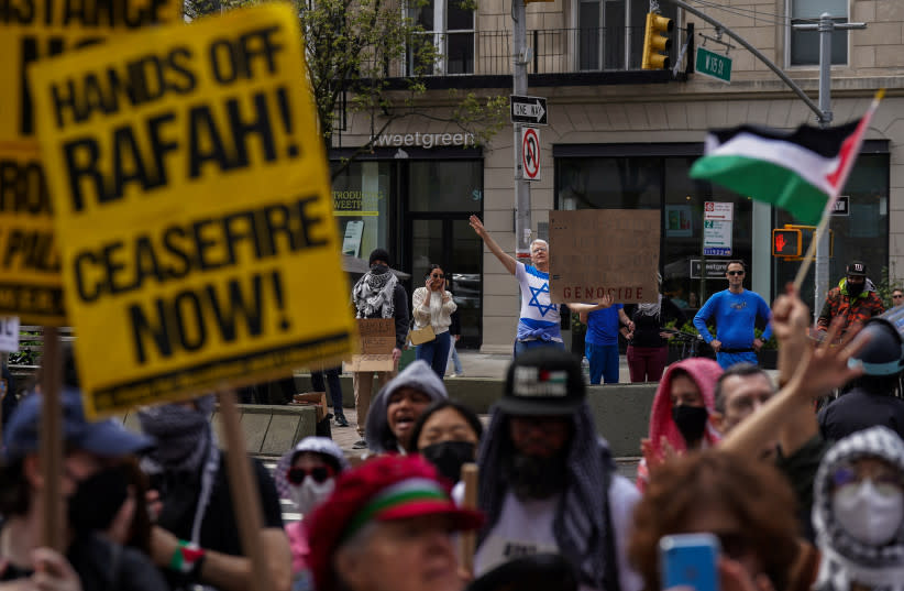 Un manifestante pro-israelí sostiene un cartel mientras los manifestantes se reúnen frente a la Universidad de Columbia para exigir un alto el fuego y el fin de los ataques israelíes contra Gaza, durante el actual conflicto entre Israel y el grupo islamista palestino Hamás, durante una protesta en