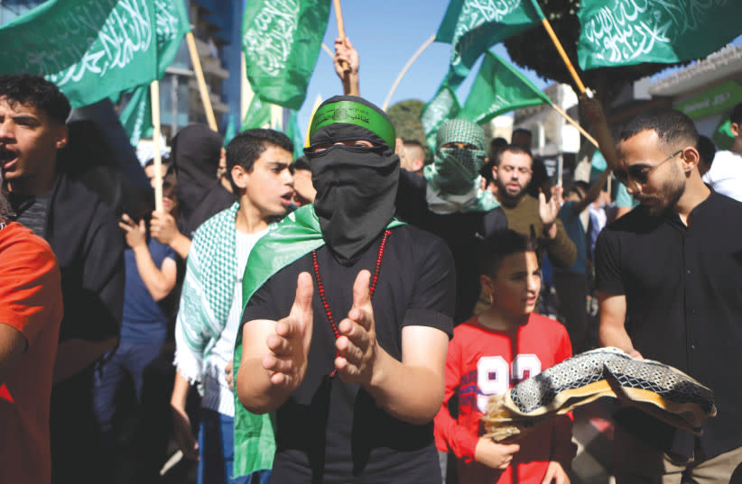  PALESTINOS ondean banderas de Hamás en Cisjordania en solidaridad con Gaza. Los llamamientos a restablecer la AP como entidad gobernante en Gaza no son menos ingenuos que los llamamientos a una ''solución de dos Estados'', afirma el autor. (credit: WISAM HASHLAMOUN/FLASH90)