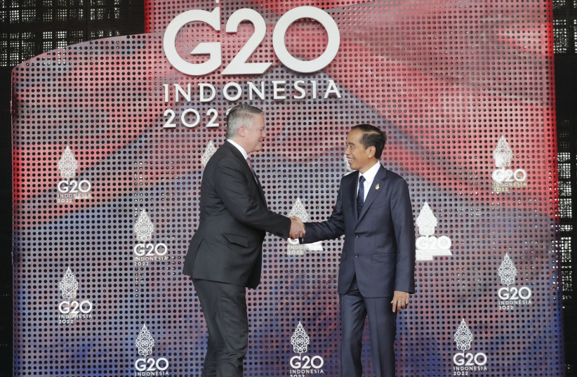  OECD SECRETARY-GENERAL Mathias Cormann (L) shakes hands with Indonesian President Joko Widodo as he arrives for the G20 leaders’ summit in Bali, Nov. 2022. (credit: Mast Irham/Pool/AFP via Getty Images)