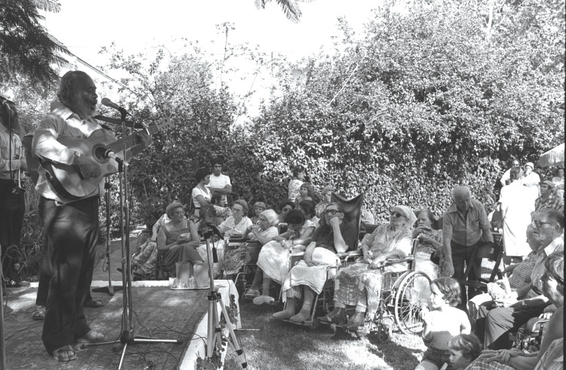  RABBI SHLOMO CARLEBACH performs before chronically ill patients in Yad Eliyahu in 1980.  (credit: Moshe Milner/GPO)