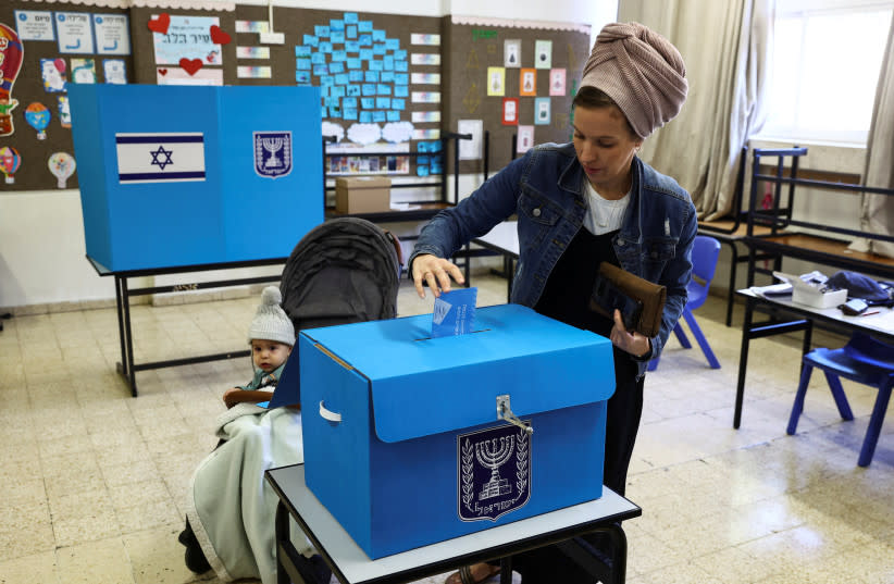  Una mujer israelí deposita su voto el día de las elecciones generales de Israel en un colegio electoral de Kiryat Arba, un asentamiento judío de Cisjordania 1 de noviembre de 2022. (credit: REUTERS/Ronen Zvulun)