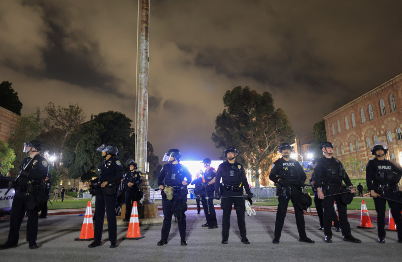  CHP officers stand guard near an area showing messages of support for Israeli hostages in Gaza, amid clashes at a nearby pro-Palestinian encampment on the University of California, Los Angeles (UCLA) campus in Los Angeles, California, U.S., May 1, 2024. (credit: REUTERS/DAVID SWANSON)
