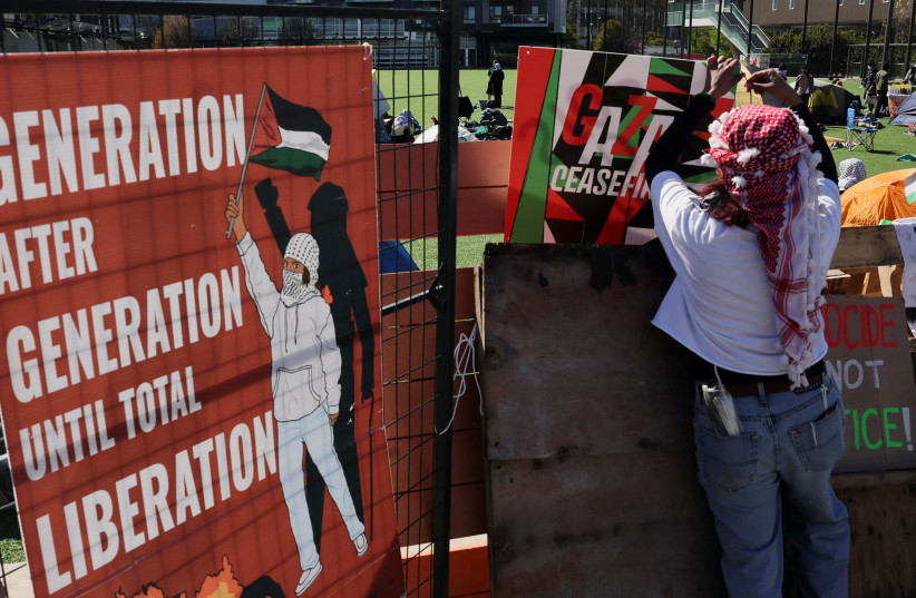  Una persona cuelga un letrero en un campamento de protesta en apoyo a los palestinos, en medio del conflicto en curso entre Israel y el grupo islamista palestino Hamas, en la Universidad de Columbia Británica (UBC) en Vancouver, Columbia Británica, Canadá, 29 de abril de 2024. (crédito: REUTERS/CHRIS HELGREN)