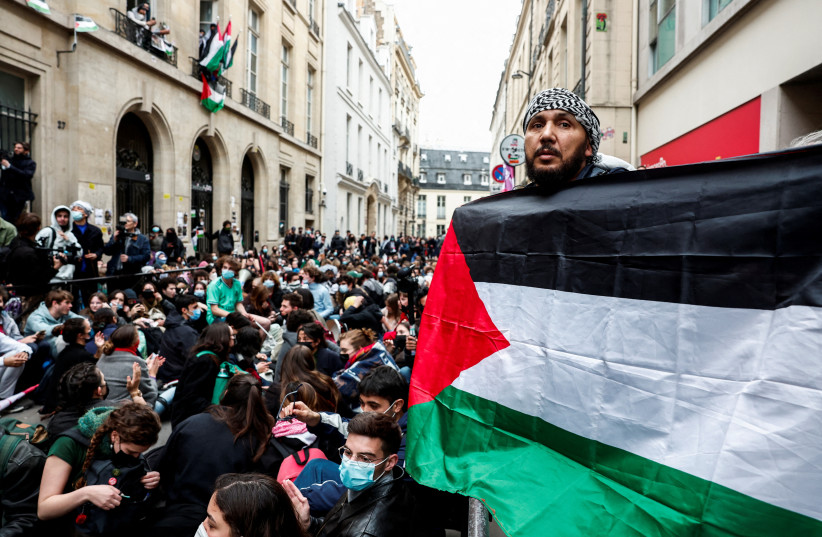  A person holds a Palestinian flag as people take part in the occupation of a street in front of the building of the Sciences Po University in support of Palestinians in Gaza, during the ongoing conflict between Israel and the Palestinian Islamist group Hamas, in Paris, France, April 26, 2024. (credit: REUTERS/GONZALO FUENTES)
