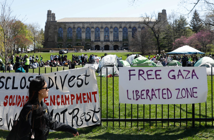 Signs are displayed in front of Deering Meadow, where an encampment of students are protesting in support of Palestinians, during the ongoing conflict between Israel and the Palestinian Islamist group Hamas, at Northwestern University campus in Evanston, Illinois, US. April 25, 2024 (credit: REUTERS/Nate Swanson)