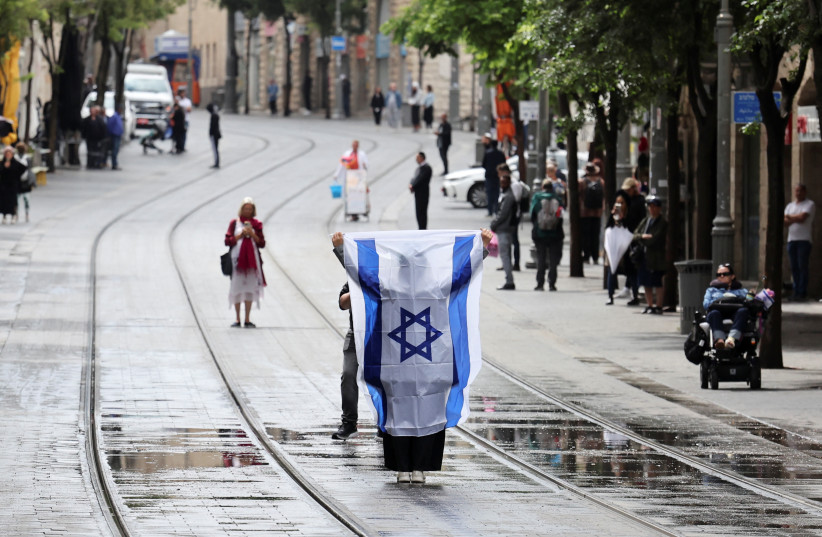Люди стоят неподвижно во время двухминутной сирены, посвященной ежегодному Дню памяти жертв Холокоста в Израиле, Иерусалим, 6 мая 2024 года. (Фото: NIR ELIAS/REUTERS)