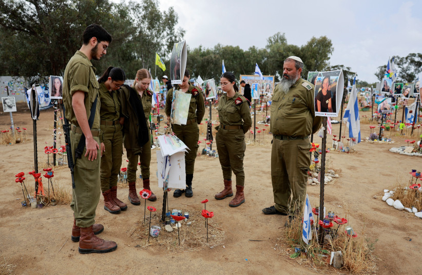  Israeli soldiers stand during a two-minute siren marking the annual Israeli Holocaust Remembrance Day, at an installation at the site of the Nova festival where party goers were killed and kidnapped during the October 7 attack by Hamas gunmen from Gaza, in Reim, southern Israel, May 6, 2024. (credit: AMMAR AWAD/REUTERS)