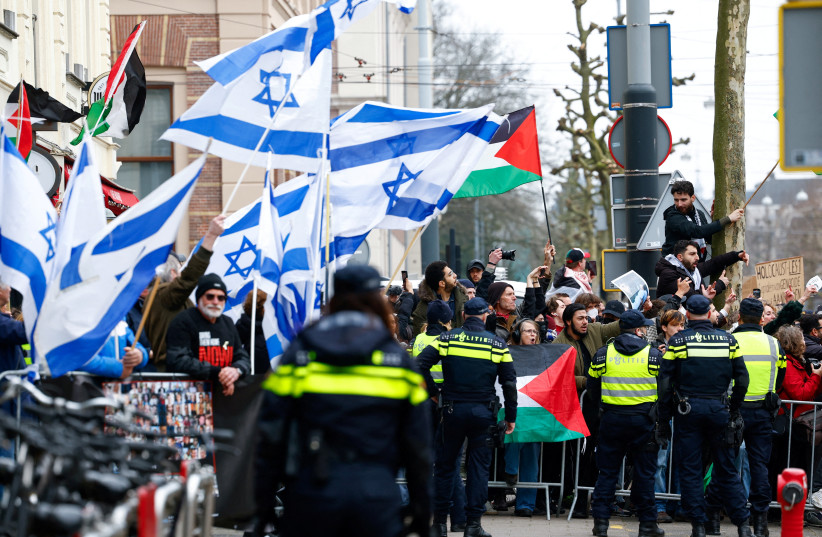  Demonstrators hold Palestinian and Israeli flags as they gather in front of the National Holocaust Museum on the day of its opening, in Amsterdam, Netherlands, March 10, 2024. (credit: REUTERS/PIROSCHKA VAN DE WOUW)