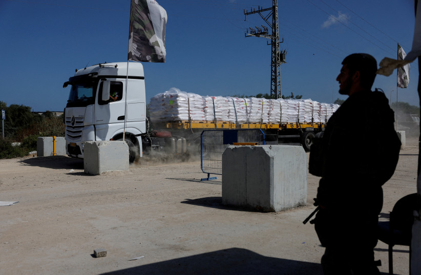  An Israeli soldier stands guard as a truck carrying humanitarian aid makes its way to the Gaza Strip at Erez Crossing in southern Israel, May 5, 2024. (credit: REUTERS/AMIR COHEN)