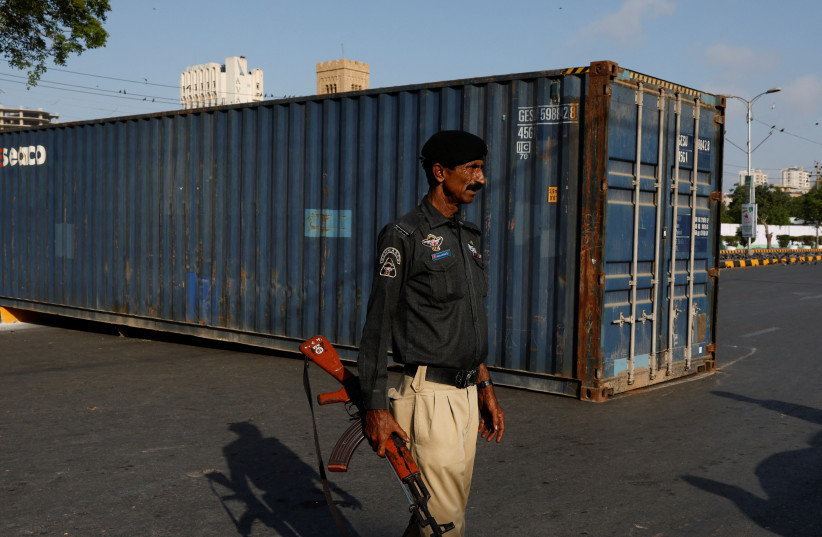  A police officer stands guard in front of a shipping container, used to block the area for security measures, in Karachi, Pakistan, April 23, 2024. (credit: REUTERS)