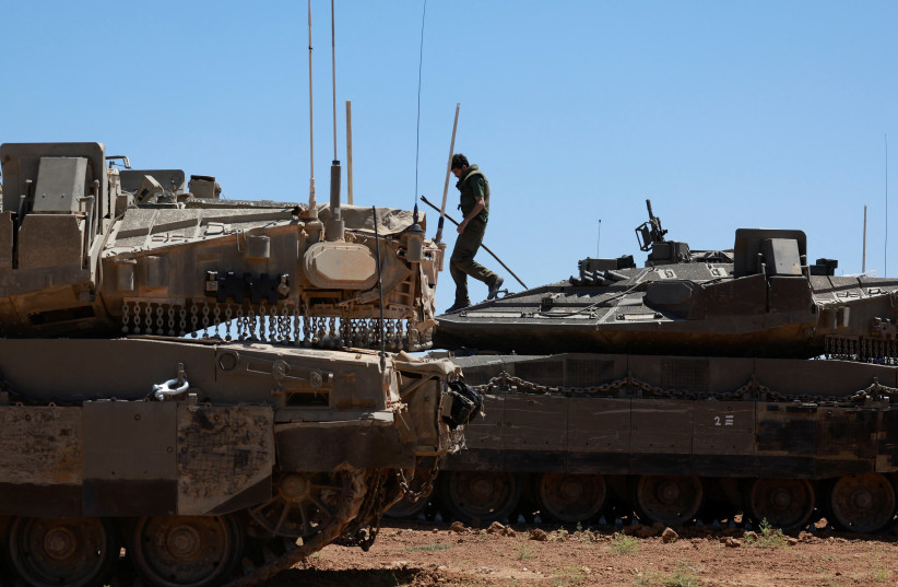  IDF soldiers gather next to tanks near the Israel-Gaza border, May 8, 2024 (credit: AMMAR AWAD/REUTERS)