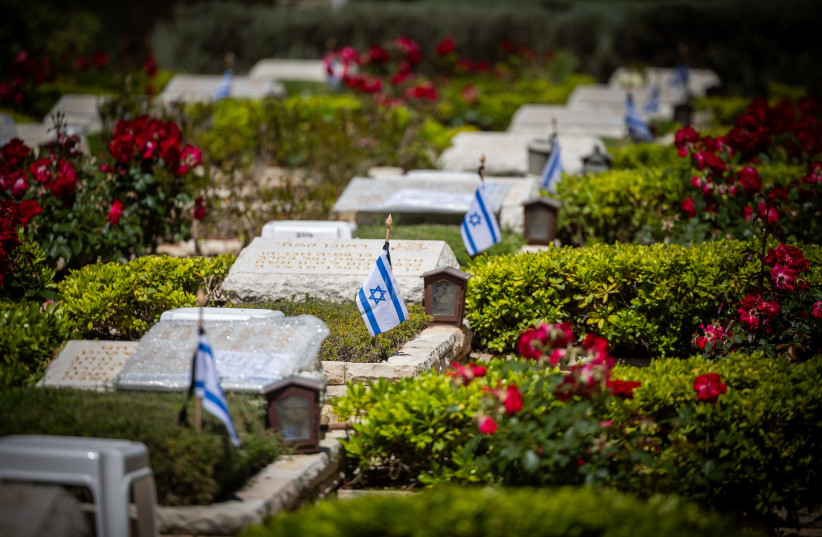  Israeli flags on graves of fallen soldiers in Mount Herzl Military Cemetery in Jerusalem, on May 9, 2024, ahead of Israeli Memorial Day. (credit: YONATAN SINDEL/FLASH90)