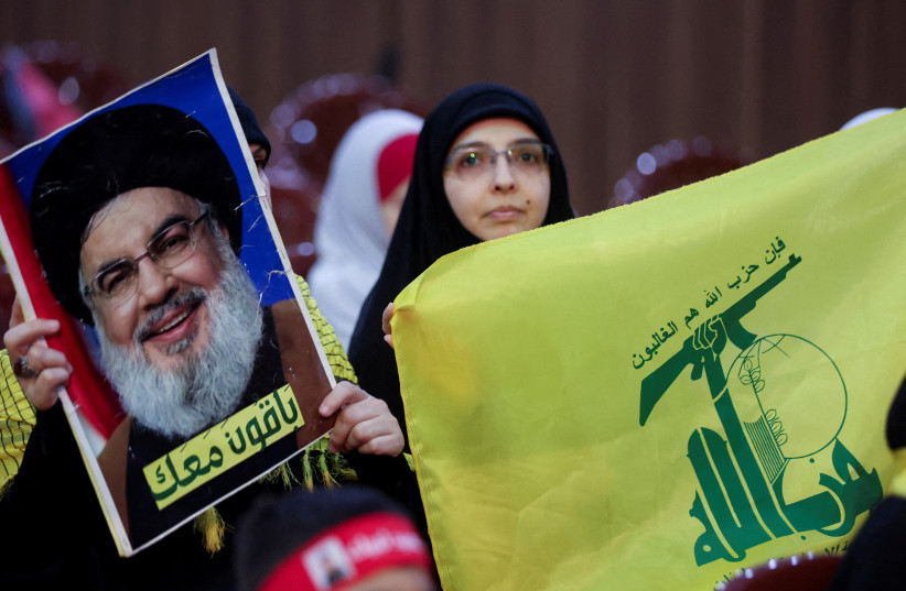  Hezbollah supporters carry a flag and a picture of Hezbollah leader Sayyed Hassan Nasrallah during a rally marking al-Quds Day, (Jerusalem Day) in Beirut's southern suburbs, Lebanon, April 5, 2024.  (credit: MOHAMED AZAKIR/REUTERS)