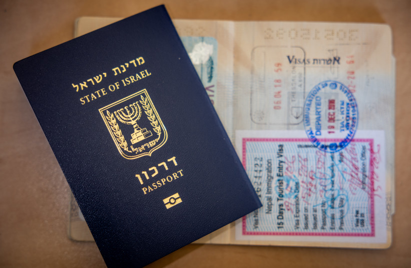 Una imagen ilustrativa muestra un nuevo pasaporte israelí y un antiguo pasaporte israelí con sellos diferentes en Jerusalén, el 18 de enero de 2023 (credit: ILLUSTRATIVE; NATI SHOHAT/FLASH90)