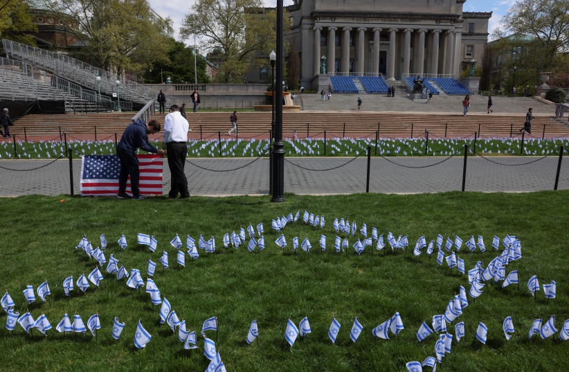  Students place flags near the main lawn of Columbia University, to show support for the Jewish community on campus, for peaceful solutions, and commemorate all lives lost since October 7, 2023, across from a student protest encampment in support of Palestinians, during the ongoing conflict between  (credit: REUTERS/CAITLIN OCHS)