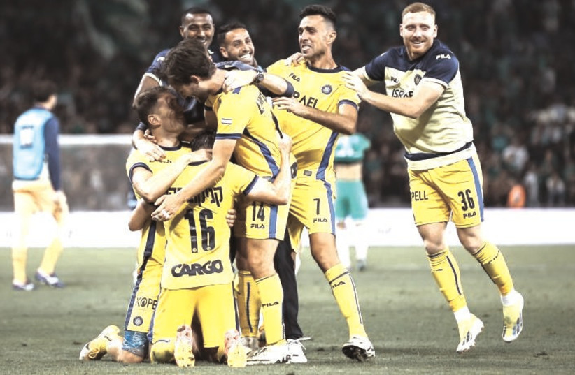  MACCABI TEL AVIV teammates celebrate on the pitch during their 1-0 away victory over Maccabi Haifa at Sammy Ofer Stadium, a result that virtually clinched the Israel Premier League championship for the yellow-and-blue. (credit: MACCABI TEL AVIV)