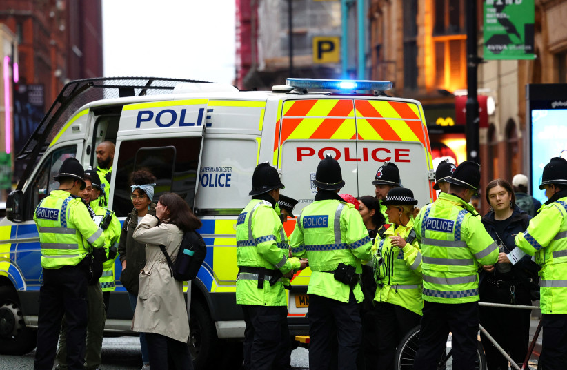 Police speak with people after detaining a man with a Palestine flag at a vigil for Israel held by Manchester Jewish Community in Manchester, Britain, October 11, 2023