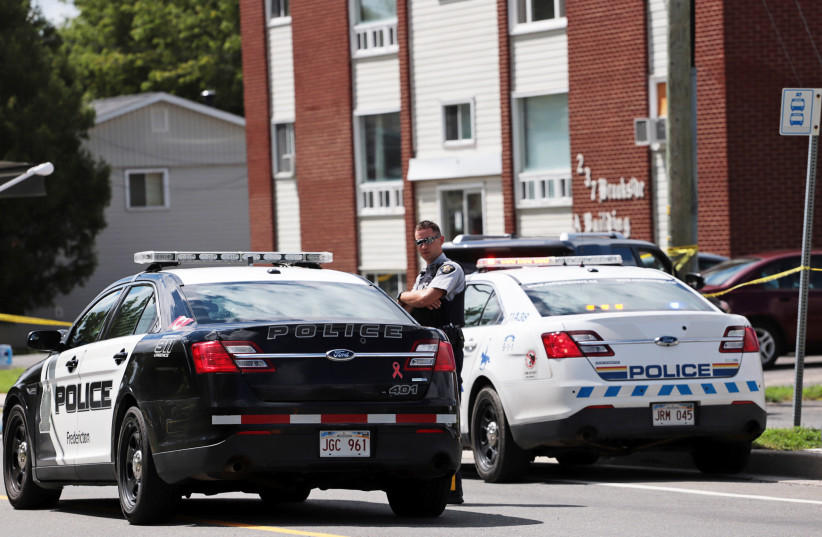  Fredericton Police and Royal Canadian Mounted Police (RCMP) patrol in front of the apartment complex which was the scene of a shooting incident in Fredericton, New Brunswick, Canada August 10, 2018. (credit: REUTERS/Dan Culberson)
