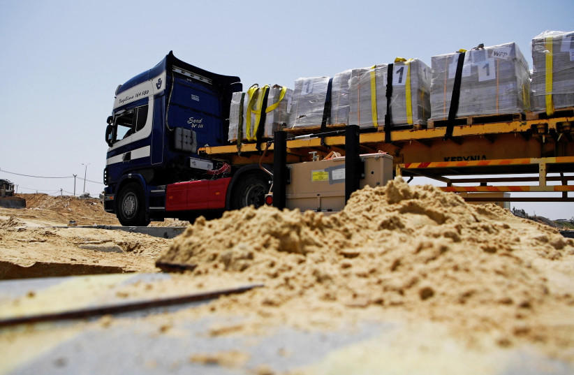 Trucks deliver humanitarian aid over a temporary pier on the Gaza coast, May 18, 2024 (credit: US ARMY CENTRAL/HANDOUT VIA REUTERS)