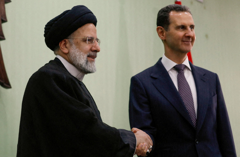   Syria's President Bashar al-Assad shakes hands with Iranian President Ebrahim Raisi during the signing of cooperation agreement in Damascus, Syria May 3, 2023.  (credit: YAMAM AL SHAAR/REUTERS)