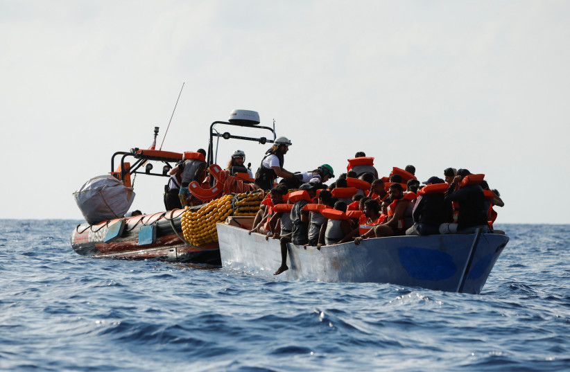  Crew members of the Geo Barents migrant rescue ship, operated by Medecins Sans Frontieres (Doctors Without Borders), distribute life jackets to a group of 61 migrants on a boat during a rescue operation in international waters off the coast of Libya in the central Mediterranean Sea September, 2023. (credit: REUTERS/DARRIN ZAMMIT LUPI)