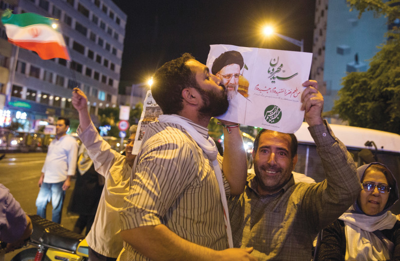  A SUPPORTER of then-Iranian presidential candidate Ebrahim Raisi kisses his poster during a campaign rally in Tehran, in 2017. (credit: TIMA VIA REUTERS)