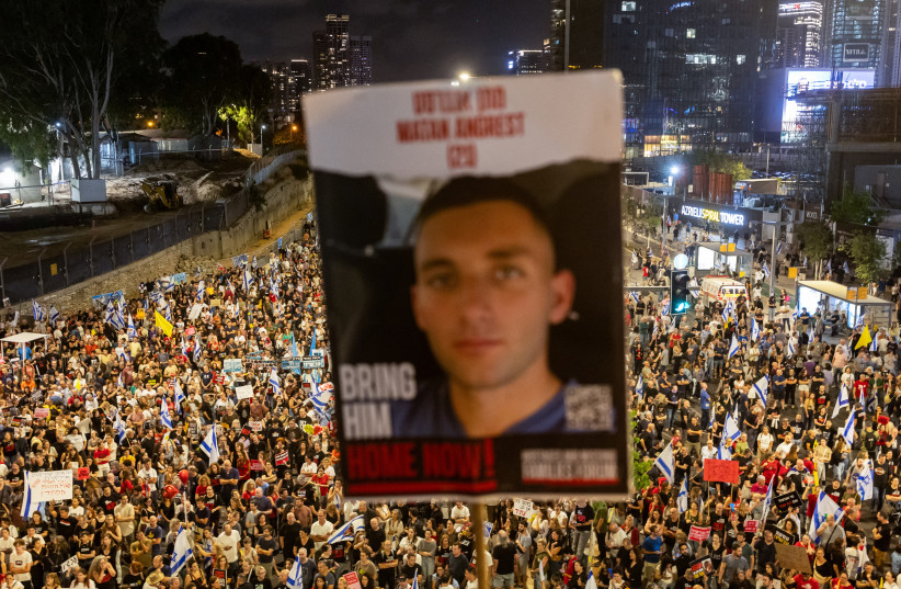 A poster of a hostage kidnapped in the October 7 attack is seen as people attend a protest in Tel Aviv, Israel, May 25, 2024 (credit: REUTERS/MARKO DJURICA)