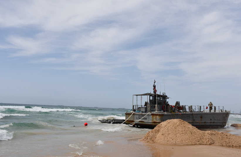  A US Army landing craft that became stranded on the coast near Ashdod attached via rope to the USAV Matamoros off the coast on May 26. (credit: SETH J. FRANTZMAN)