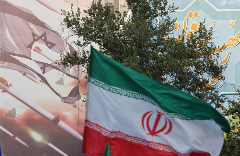 Una valla publicitaria anti-israelí se ve junto a la bandera iraní durante una celebración tras el ataque de la IRGC a Israel, en Teherán, Irán, 15 de abril de 2024.